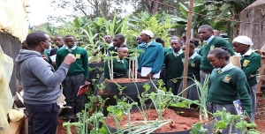 Mr. Patrick Wanjohi discussing with the learners on the vertical gardening during a School visit at CEMASTEA